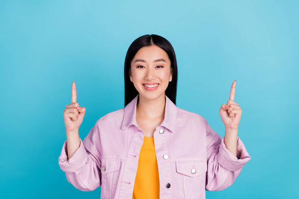 Portrait of attractive cheerful girl pointing up copy space ad solution look isolated over bright blue color background - Фото, зображення