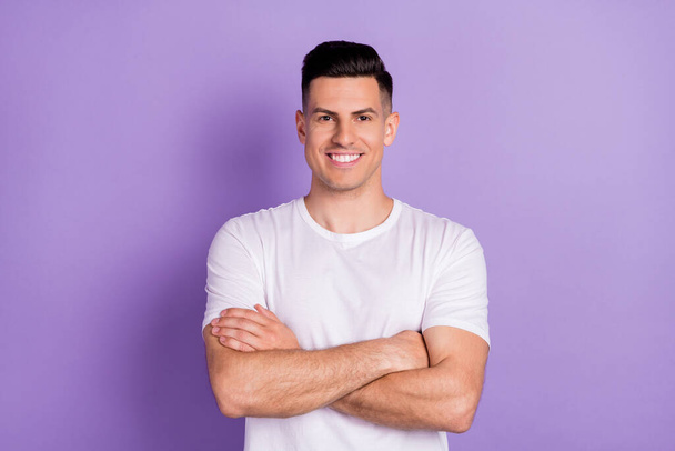 Photo of young happy positive confident man hold hands crossed good mood smile isolated on purple color background - Foto, Imagem