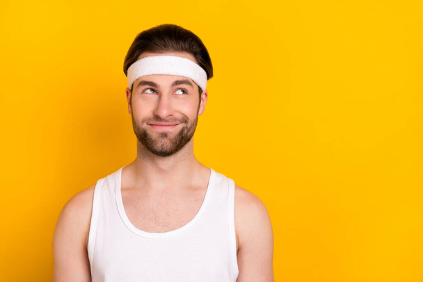 Portrait of attractive cheerful curious guy sportsman thinking copy space isolated over bright yellow color background - Φωτογραφία, εικόνα