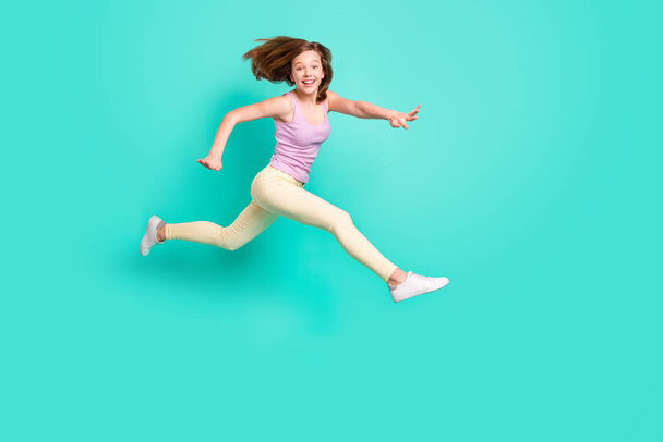 Full body profile photo of impressed brown teen girl jump run wear top pants isolated on teal color background - Photo, Image