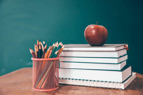 Back to School Concept. Apple, accessories and books against chalkboard. - Fotó, kép