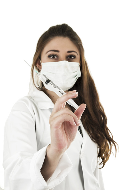 Beautiful friendly female doctor wearing a mask holding an injection - Fotoğraf, Görsel