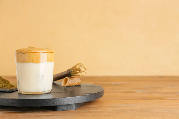 Ποτήρι νόστιμο dalgona hojicha latte και chasen στο τραπέζι - Φωτογραφία, εικόνα