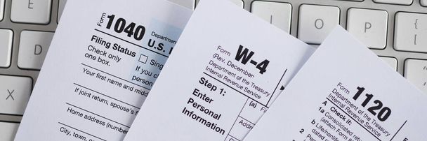 Documentos de formulario de impuestos que se encuentran en primer plano teclado de la computadora - Foto, imagen