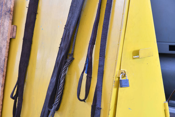 Des élingues en nylon pour soulever les charges sur la grue télphérique se trouvent sur le rack. - Photo, image