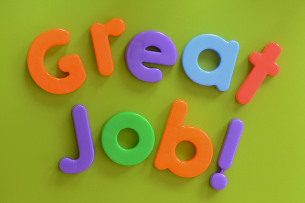 ¡Primer plano de Gran Trabajo! palabras en letras de plástico de colores sobre fondo verde
 - Foto, Imagen