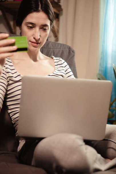 Fiatal magabiztos csinos nő dolgozik laptop és átutalás pénzt online banki segítségével vezeték nélküli internet kapcsolat laptop. Bankkártyával rendelkező nő, aki személyes fizetési adatokat ad meg. - Fotó, kép