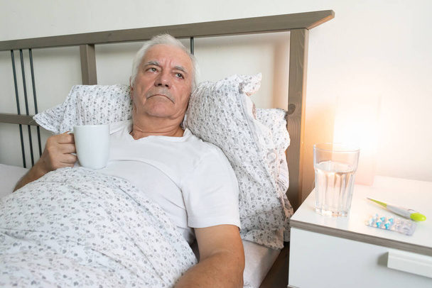 старіння старший чоловік чоловік в ліжку вдома втомлений хворий один вірус відпочинку на пенсії, піклуючись про нещасний сум
 - Фото, зображення