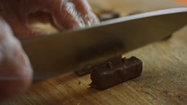 Leikkaa snickers pieniksi paloiksi ja lisää jäätelö kulhoon. 4k-video - Materiaali, video