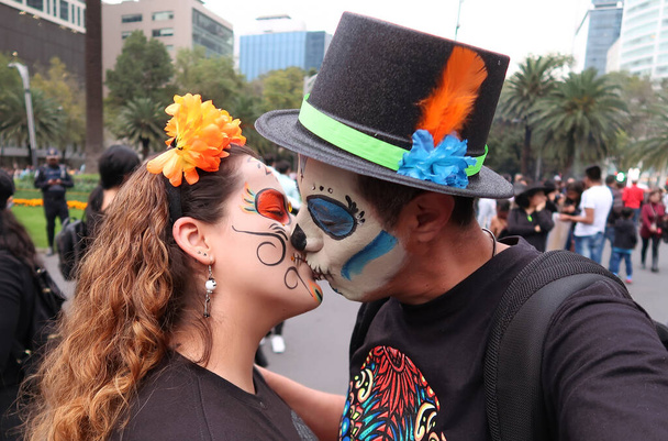 Cadılar Bayramı 'nda Catrina kostümü giymiş iki kadın öpüşüyor. - Fotoğraf, Görsel