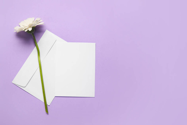 Envelope with blank card and flower on color background - Photo, Image