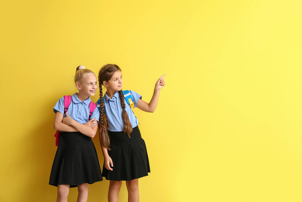Lindas colegialas apuntando a algo en el fondo de color - Foto, Imagen