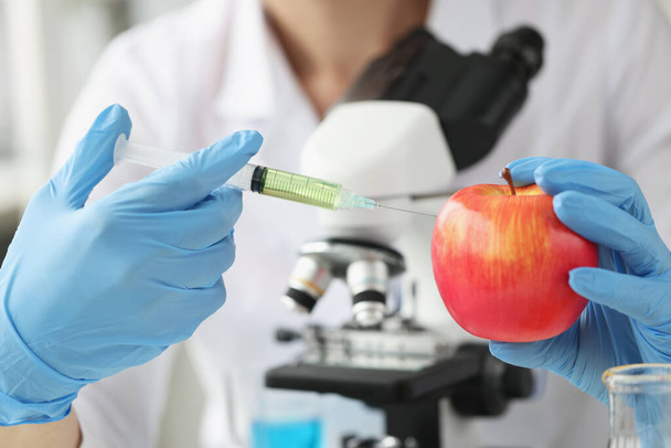 Γιατρός επιστήμονας κάνει ένεση στο μήλο στο εργαστήριο - Φωτογραφία, εικόνα