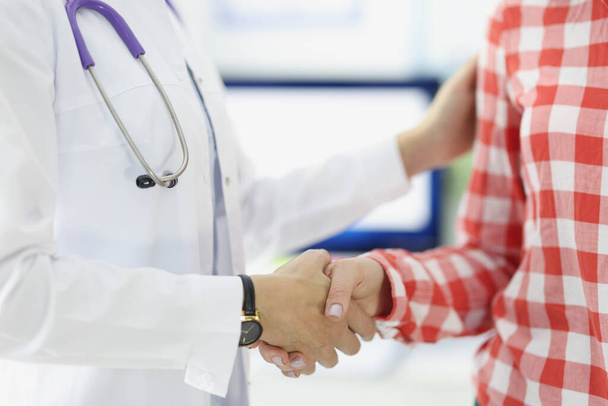 Doctor shaking hands with woman patient in clinic closeup - Photo, Image