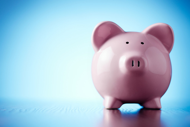 Pink piggy bank on a colorful blue background - Photo, Image