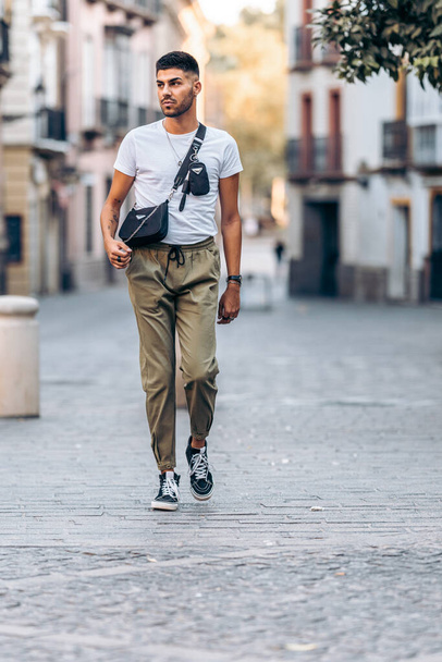 Man walking distracted through the street the street dressed in casual clothing - 写真・画像