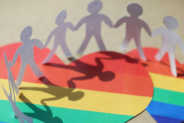 Many paper people standing on hearts with lgbt symbols closeup - Photo, Image