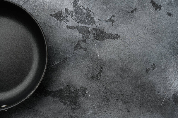 Cast iron frying pan set with copy space for text or food with copy space for text or food, top view flat lay, on gray stone table background - Photo, Image