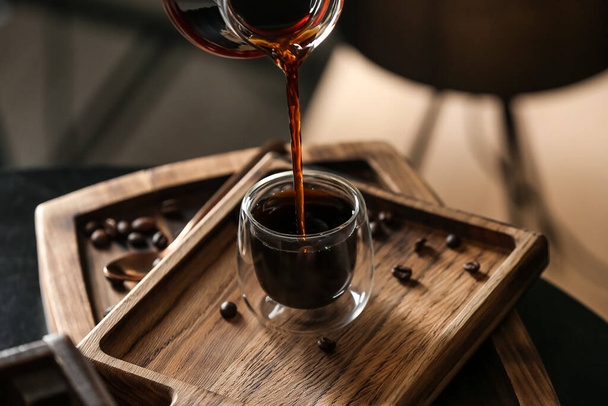 Gieten van hete Turkse koffie in glazen beker aan boord - Foto, afbeelding