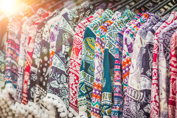 clothes hanging on a rack in a flea market Souvenir shop in Thailand - Photo, Image