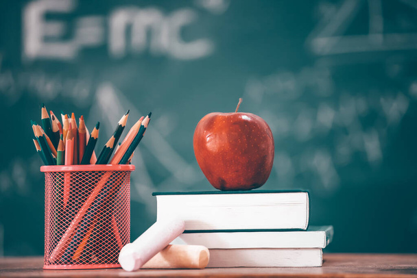 Back to School Concept. Apple, accessories and books against chalkboard. - Foto, Imagem