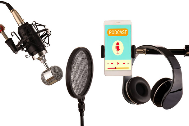 Micrófono moderno con filtro pop, auriculares y teléfono móvil sobre fondo blanco - Foto, Imagen