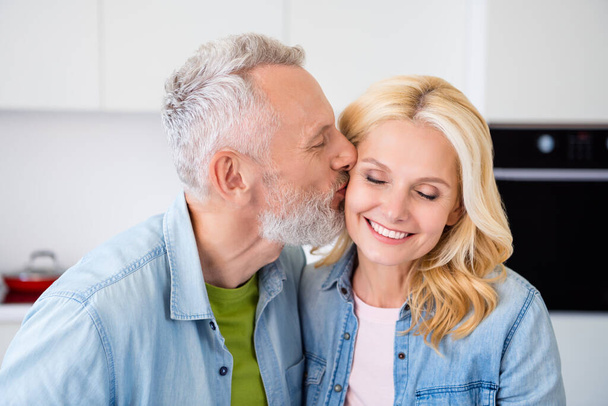 Portrait of lovely cute dreamy couple mature people enjoy weekend free time affectionate husband kiss beautiful wife - 写真・画像