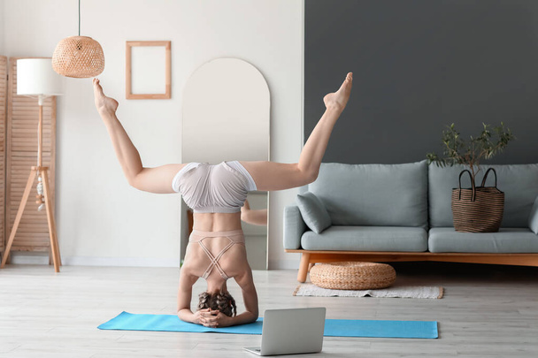 Fiatal nő jógázik otthon - Fotó, kép