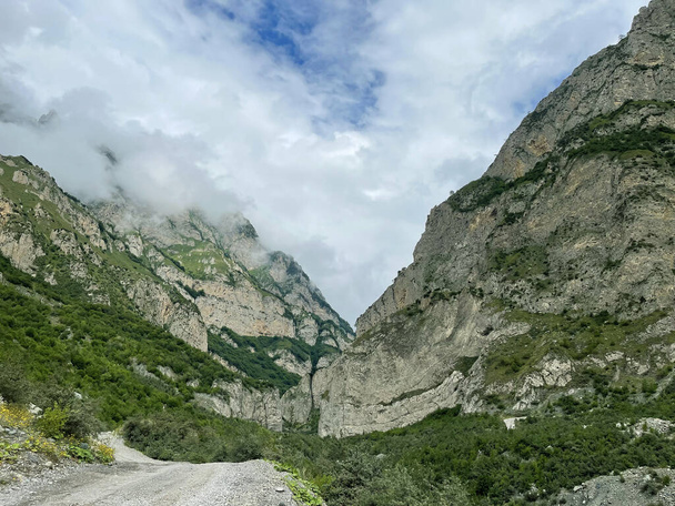 Kafkasya dağları, Kuzey Osetya, Rusya 'daki dar Karmadon Geçidi' nde kayaların arasında bir yol. - Fotoğraf, Görsel