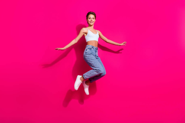 Full length body size view of pretty carefree cheerful girl jumping good mood isolated over bright pink magenta color background - Фото, изображение
