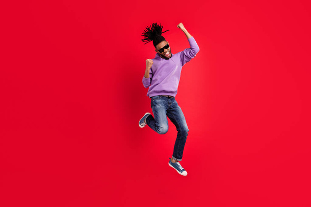 Full length body size photo man in sportswear gesuring like winner jumping up isolated vivid red color background - Valokuva, kuva