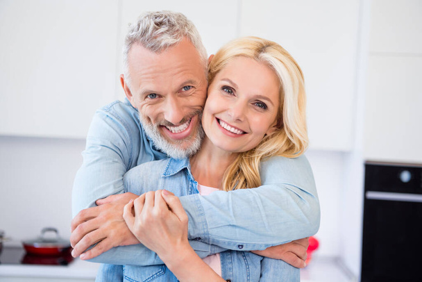 Photo of sweet pretty mature lovers dressed jeans shirt cuddling smiling indoors room home - Φωτογραφία, εικόνα