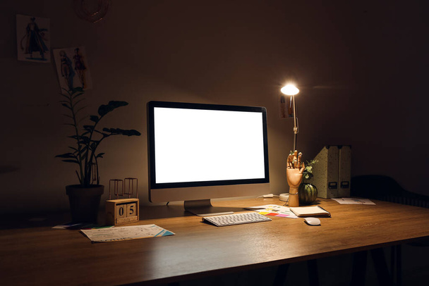 Moderno lugar de trabajo con ordenador en habitación oscura - Foto, Imagen