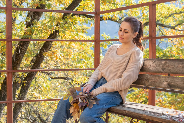 vonzó boldog középkorú nő pulóverben tartja csokor színes levelek. őszi szezon. - Fotó, kép
