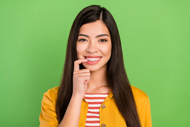 Photo of lovely brown hairdo millennial pani palec zęby nosić żółtą koszulę izolowane na zielonym tle kolor - Zdjęcie, obraz