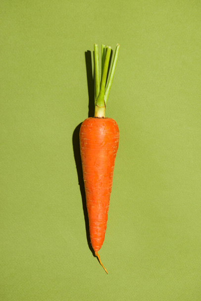 Vista superior de una zanahoria sobre fondo verde
. - Foto, Imagen