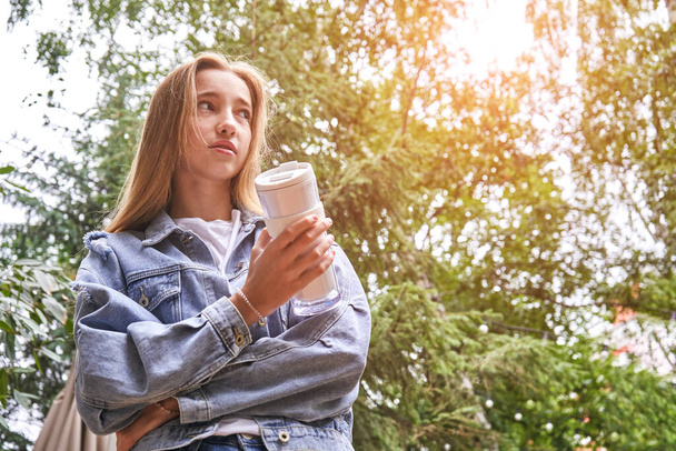 Pretty girl drink beverage outdoors. Buy takeaway coffee in own cup. Real people - Foto, Imagem