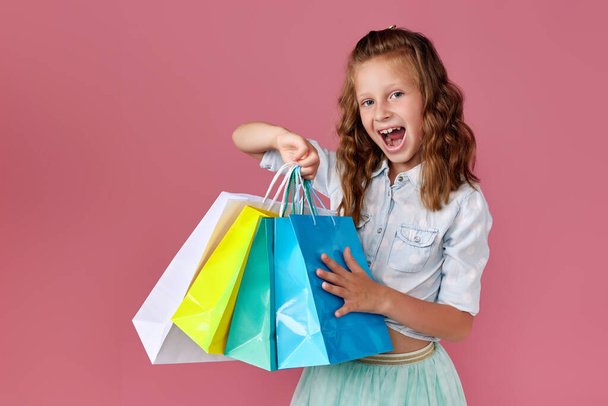 cute little caucasian child girl holds shopping bags - Fotografie, Obrázek