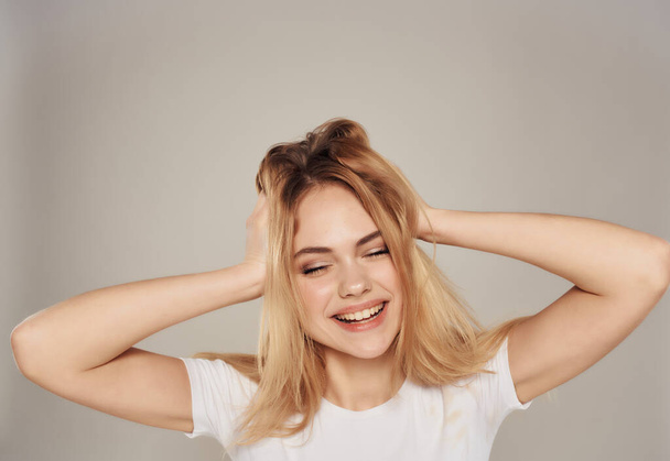 beautiful blonde in a white positive posing joy smile light background - Zdjęcie, obraz