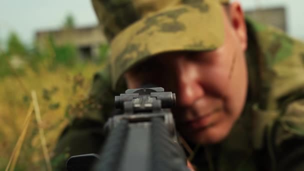 soldato maschio mira da una mitragliatrice mentre seduto in agguato - Filmati, video