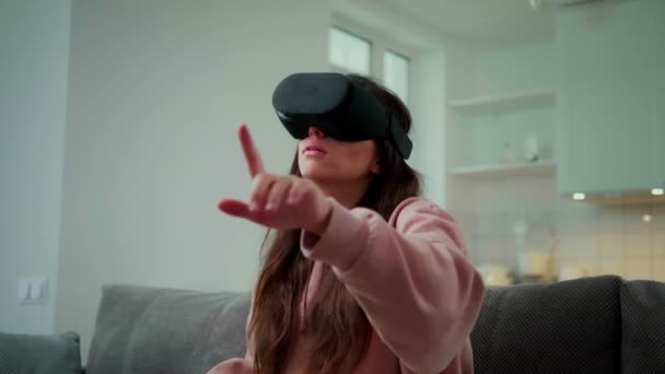 Ragazza da sola alla ricerca di internet virtuale in VR auricolare a casa. Rallentatore - Filmati, video