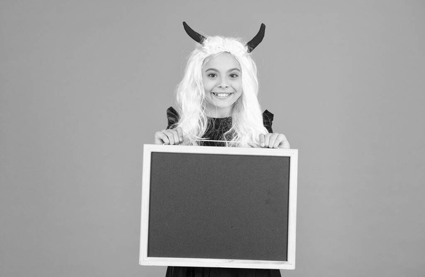 Happy Haunting. back to school. copy space. happy halloween. child in devil horns hold blackboard. kid has white hair. childhood happiness. teen girl ready to celebrate costume party. trick or treat - Foto, Imagem