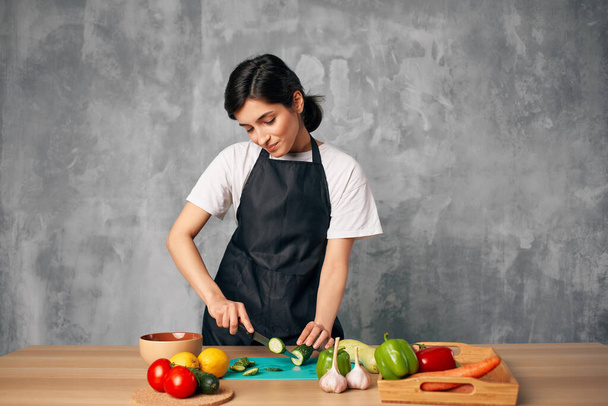 Woman in black apron Cooking healthy eating salad - Fotó, kép