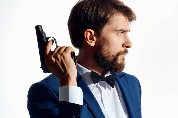 homme en costume avec un pistolet à la main arrière-plan clair - Photo, image