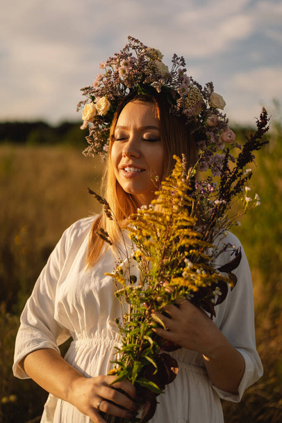Portrait of a pregnant woman. A beautiful young pregnant woman in a white dress walks in the field. - Valokuva, kuva