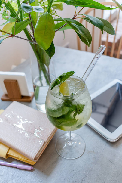 There is a glass of non-alcoholic mojito on the table in a vegetarian cafe. Healthy food concept. Hot Summer. - Photo, image
