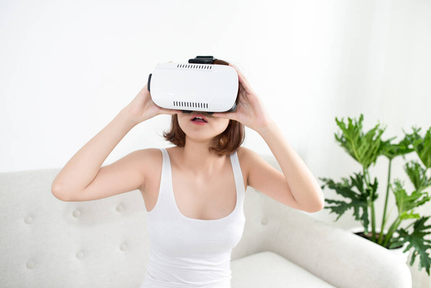 Atraktivní mladá žena nastavující si soupravu VR a usmívající se  - Fotografie, Obrázek