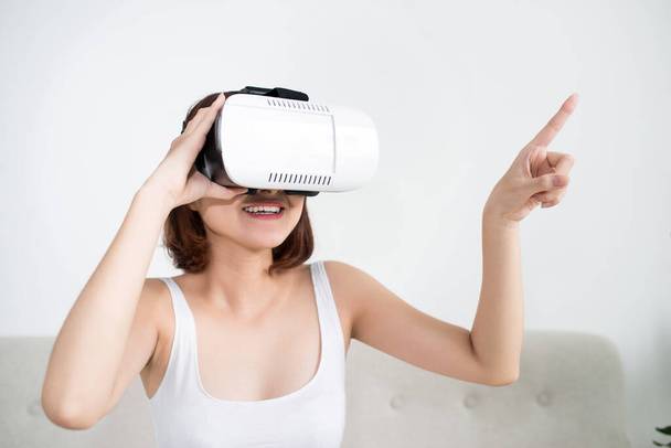 Attractive young woman adjusting her VR headset and smiling  - Photo, Image