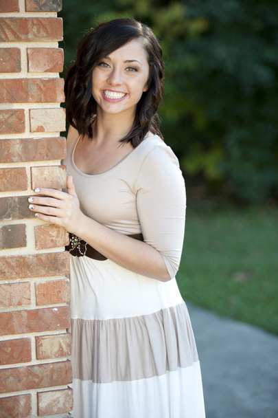 Brunette girl  posing near a brick wall - Φωτογραφία, εικόνα