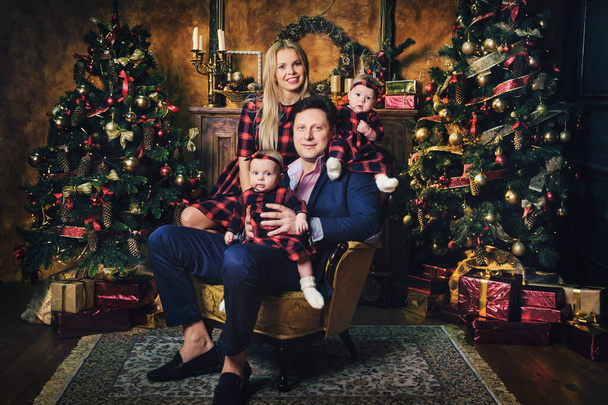 Uma família grande feliz com seus filhos no interior do Ano Novo da casa junto à lareira ao lado da árvore de Natal. - Foto, Imagem